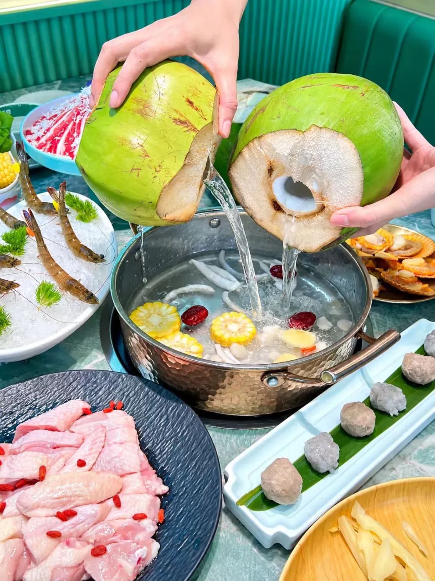 Fresh coconut water being poured straight from the shell into a simmering hotpot
