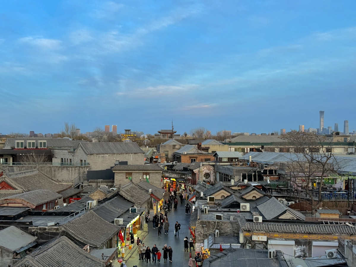 Evening crowds strolling a Beijing hutong street at dusk — everyday street life in Chinese cities is one of the safest among big-city destinations