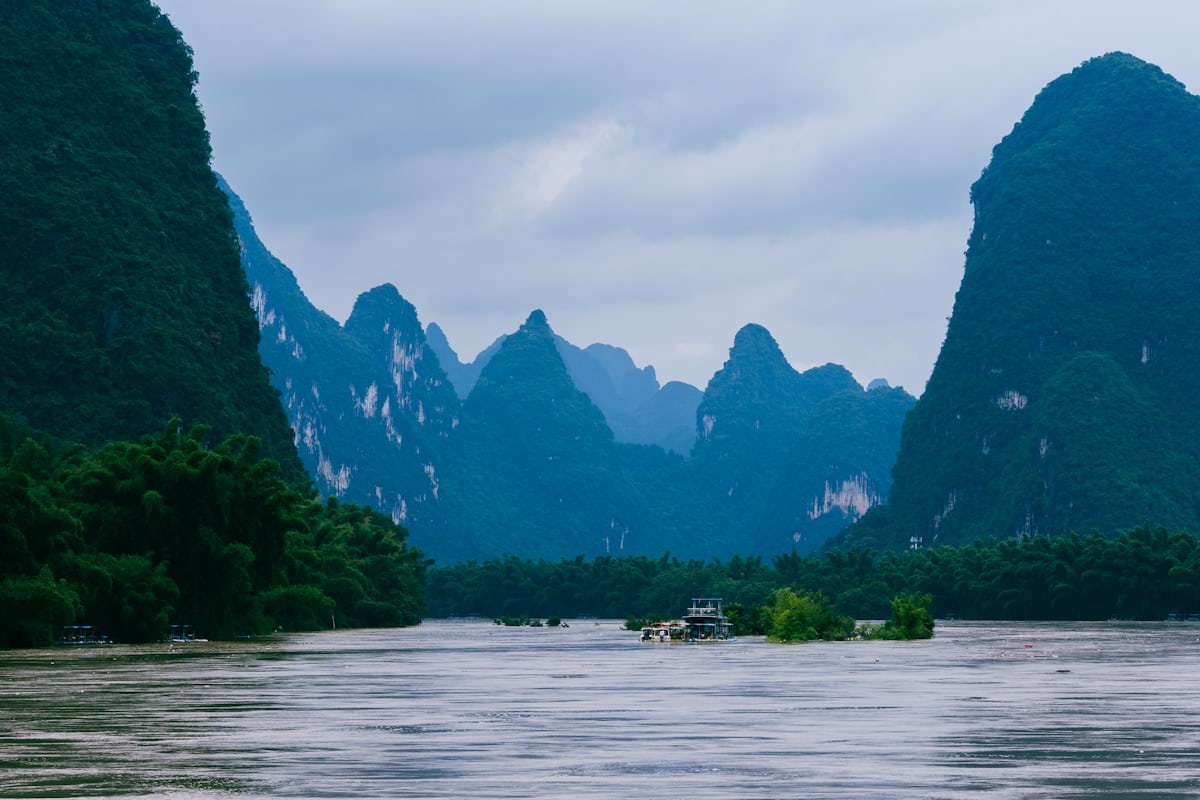 Karst peaks rise over the Li River between Guilin and Yangshuo — every boat class gets the same view