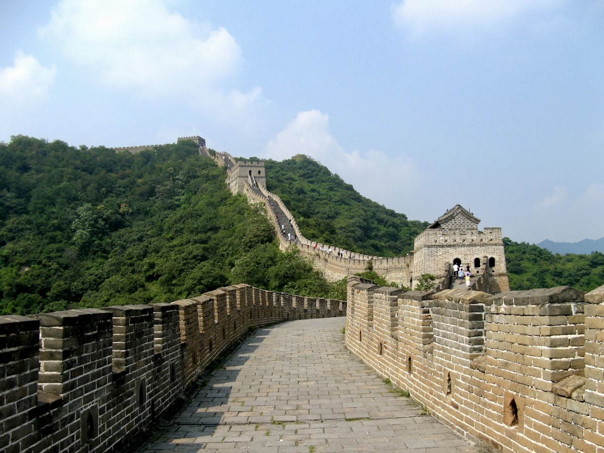 The restored Mutianyu section winding over green ridges — arrange transport before you land, not the morning of