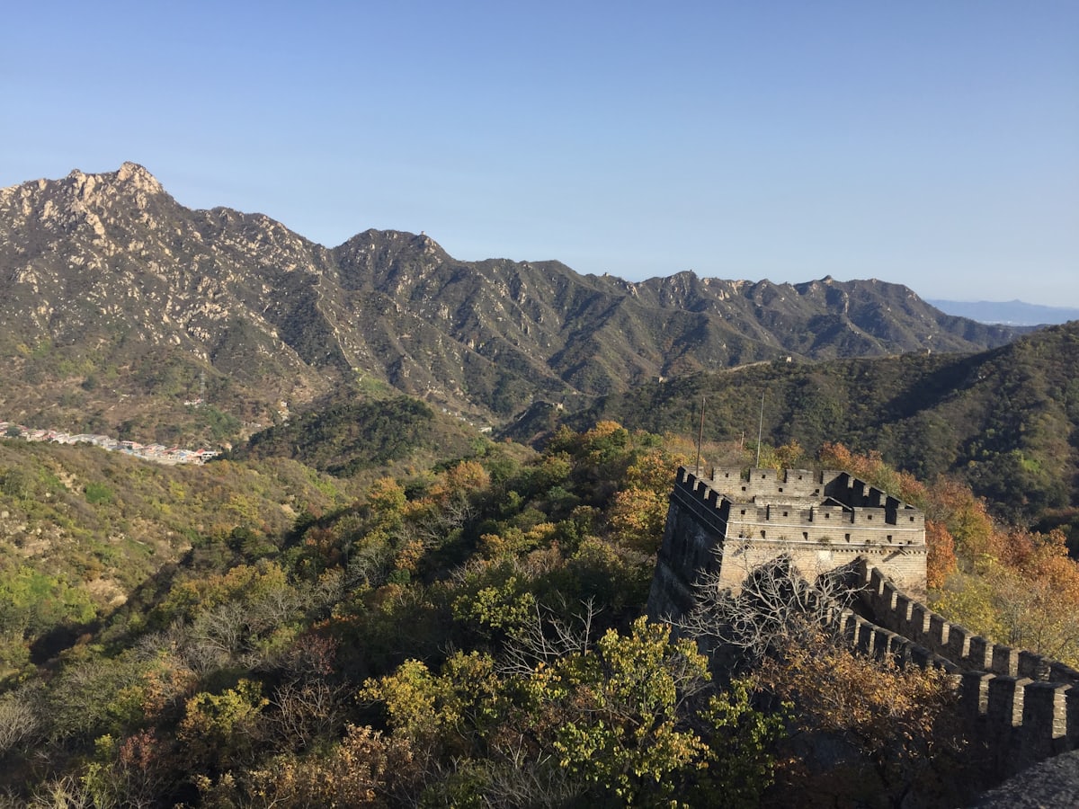 A Mutianyu watchtower above the autumn forest — restored wall without the Badaling crush