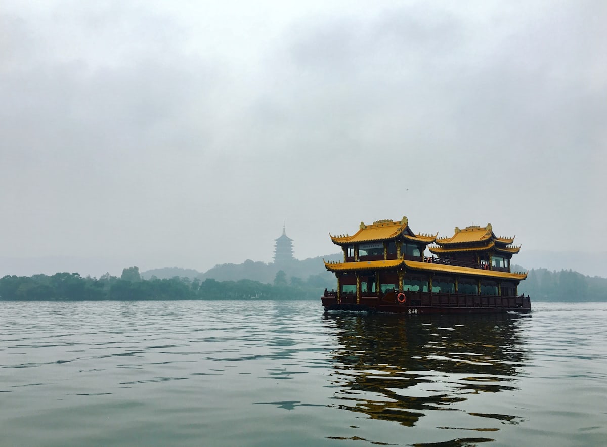 A gilded sightseeing barge on West Lake — the ¥30 tourist boats the boatmen push; locals take the ¥6 water bus instead