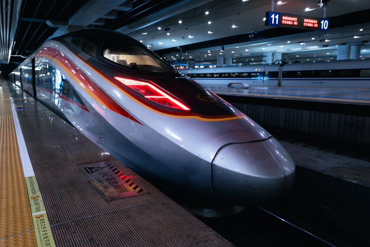 Sleek nose of a Chinese G-class high-speed train at the platform at night — the fastest Gaotie service cruises around 280 km/h