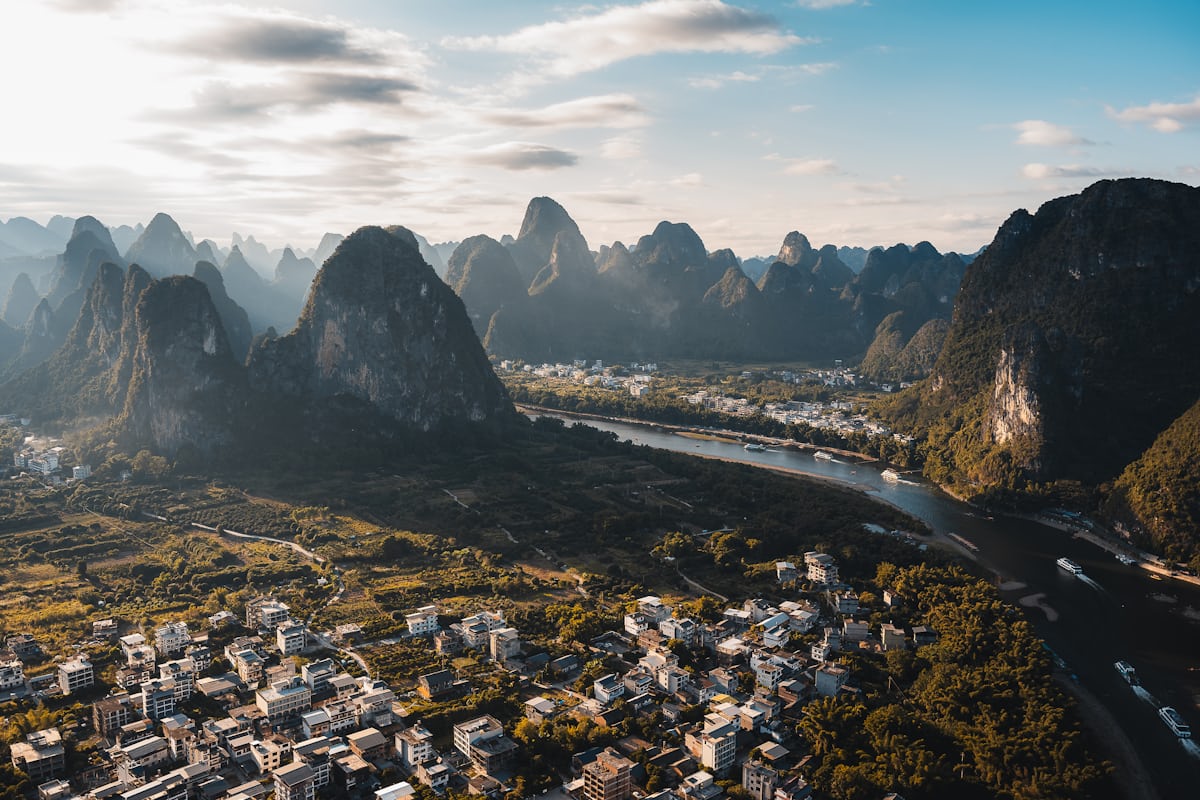 First light over a Li River bend, karst peaks fading into haze — the view that makes the 4 AM Xianggong Hill run worth it
